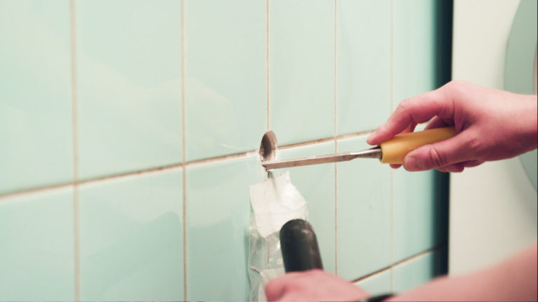 Ammattilainen ottaa näytettä kylpyhuoneesta. Muista estää pölyn pääseminen ympäristöön!